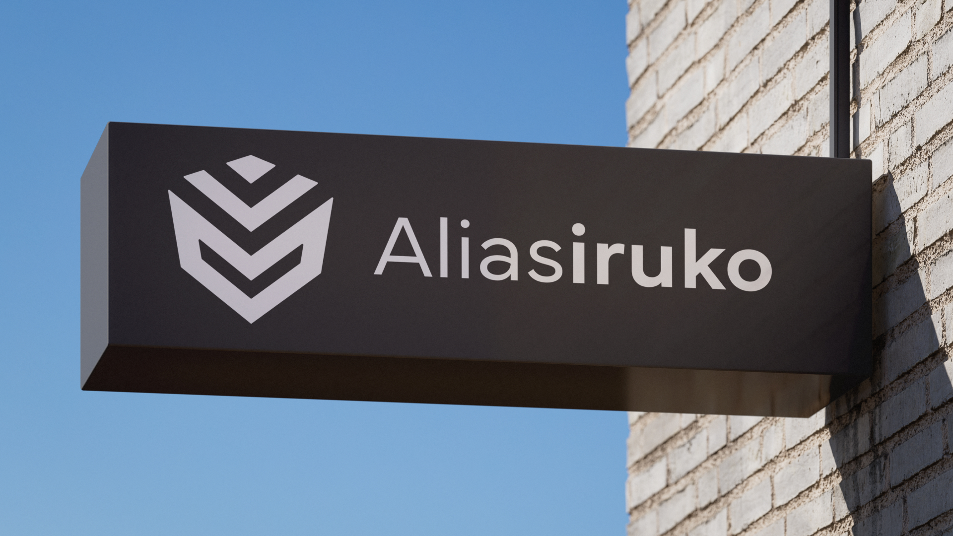 A close-up shot of a rectangular, dark gray sign mounted on a wall. The redesigned logo is visible in white.